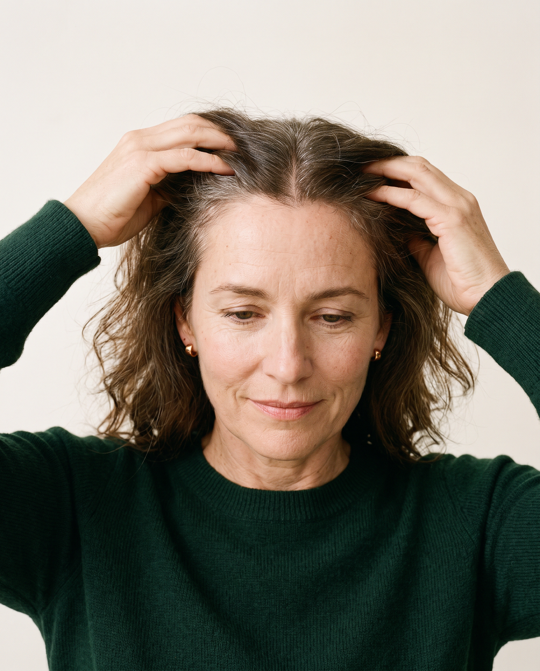 Woman parting her hair to check her centre part